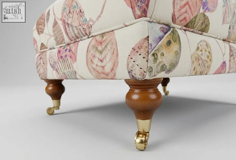 The highland foot stool is a cream upholstered footstool with shell patterns, solid wood frame, high density foam, and leg options