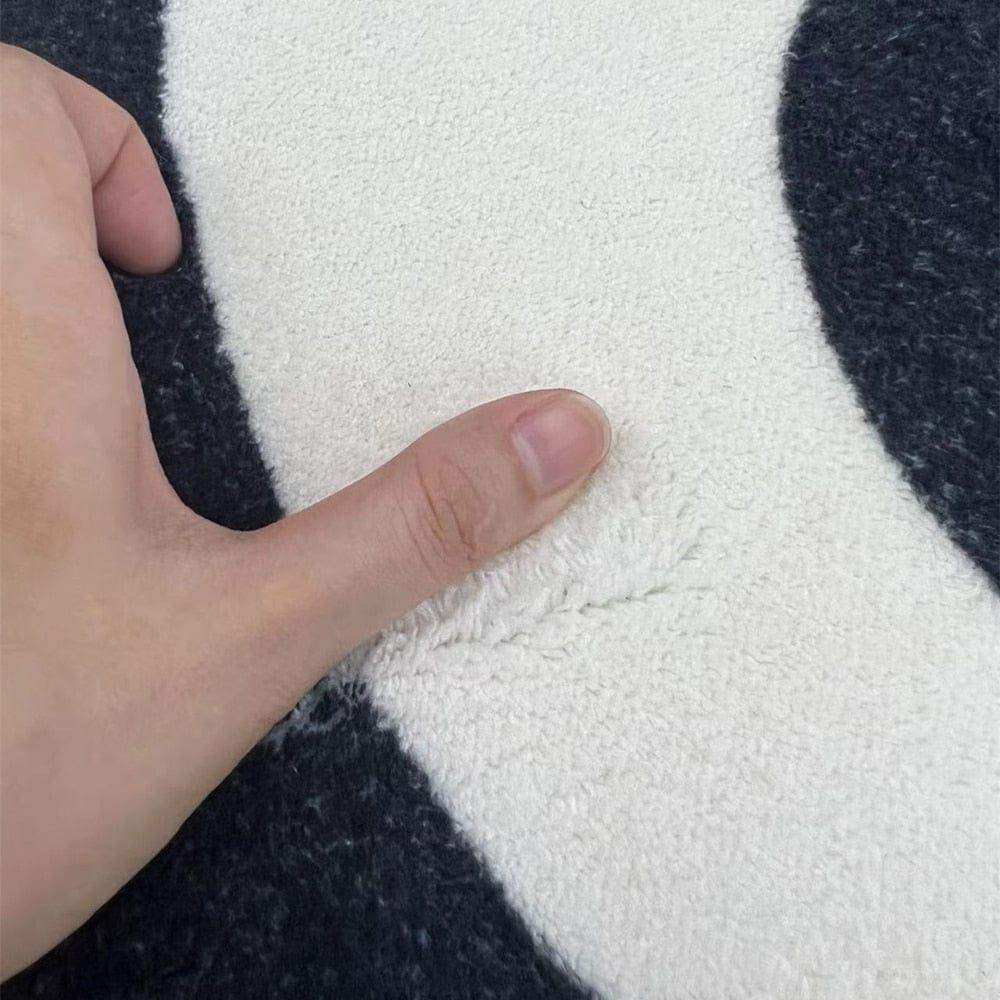 A plush soft-textured black and white illusion rug with a bold pattern perfect for stylish living spaces