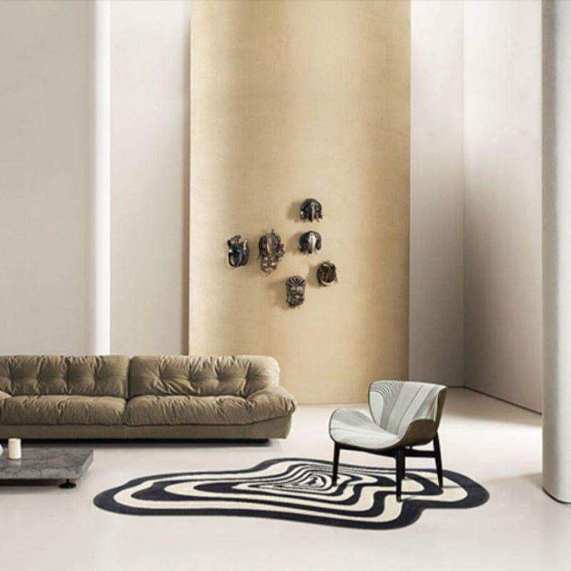 A sleek armchair with white and gray striped fabric and dark wood legs placed on the illusion rug