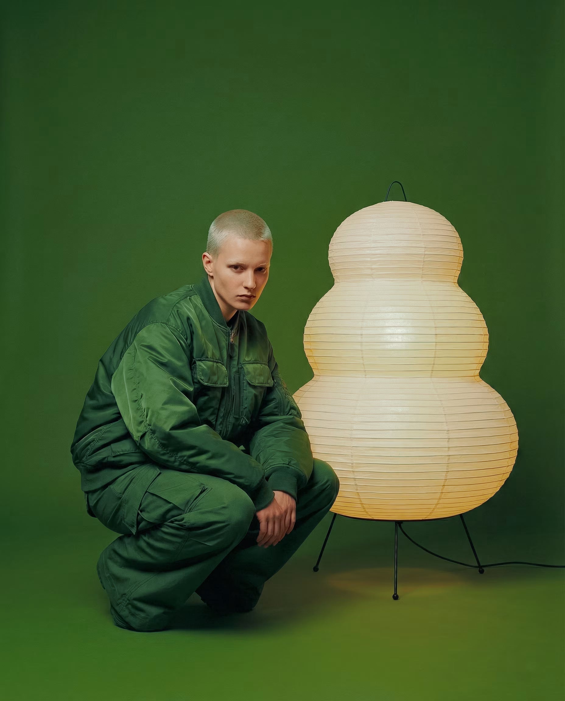 The Japanese Hikaru lamp glowing cream rice paper lantern with tiered design and black iron tripod legs