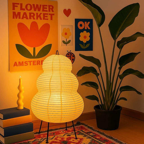 Warm yellow japanese hikaru lamp with tiered rice paper shade and black iron tripod legs for cozy lighting