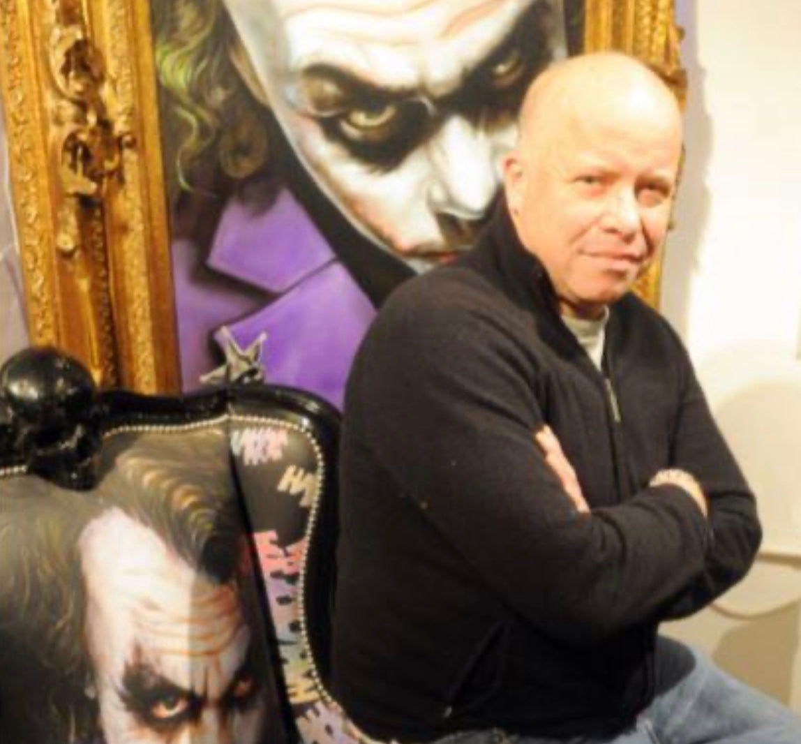 Black upholstered joker chair with printed joker face and skull shaped armrests for unique seating