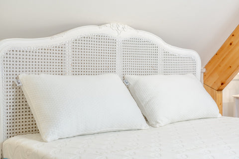 White woven cane headboard with ornate curved top and intricate lattice pattern for the luxury bamboo pillow setup