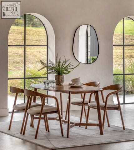 Modern med dining table in solid walnut with soft edges paired with matching light brown wooden chairs with beige seats