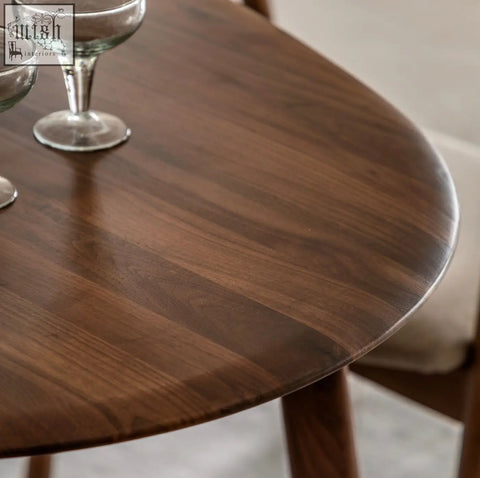A med dining table in solid walnut with a sleek dark brown finish soft edges and visible wood grain