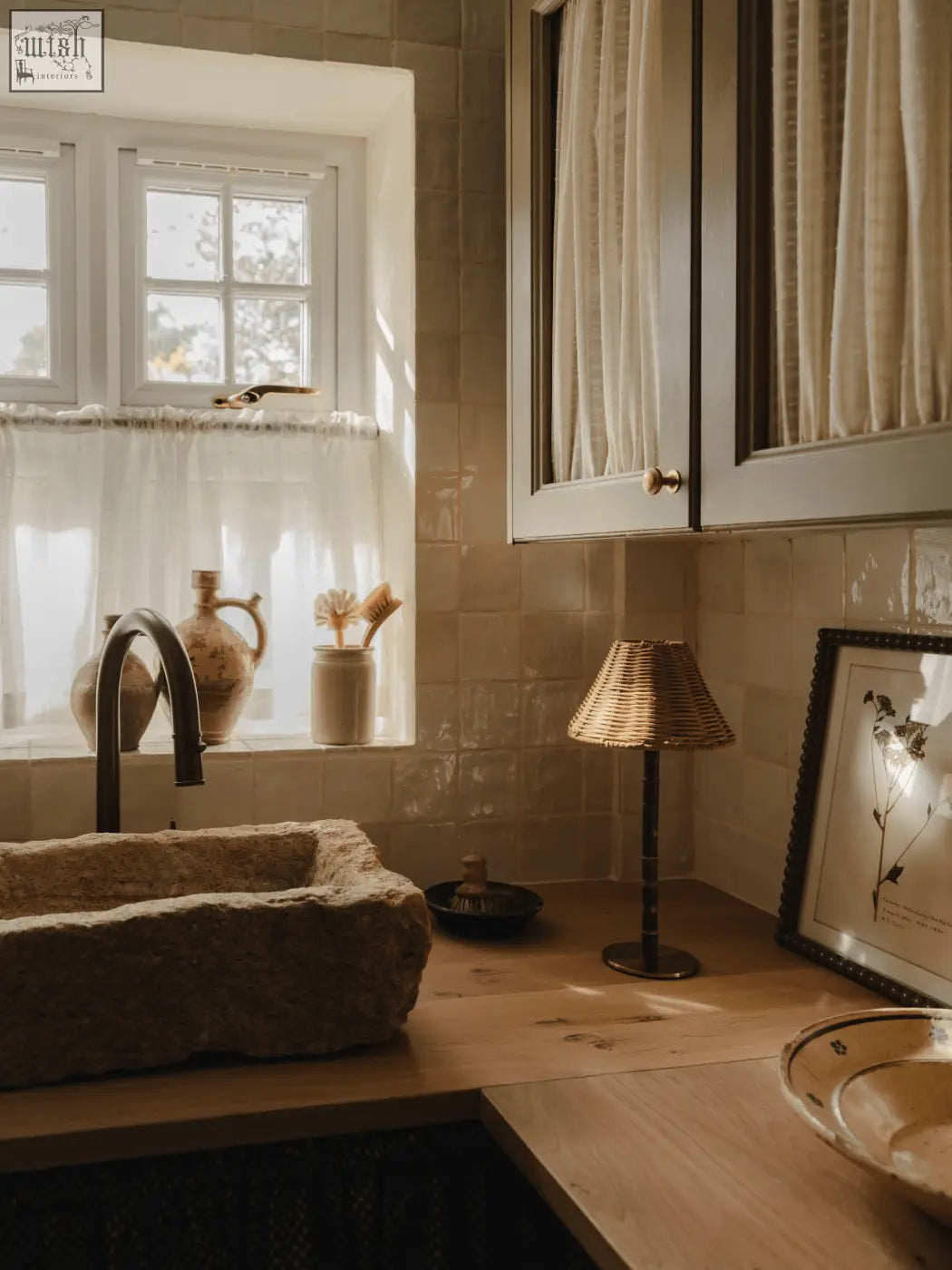 Rustic stone sink with matte earthy texture and natural edges next to raffles lamp with solid brass base and bamboo body