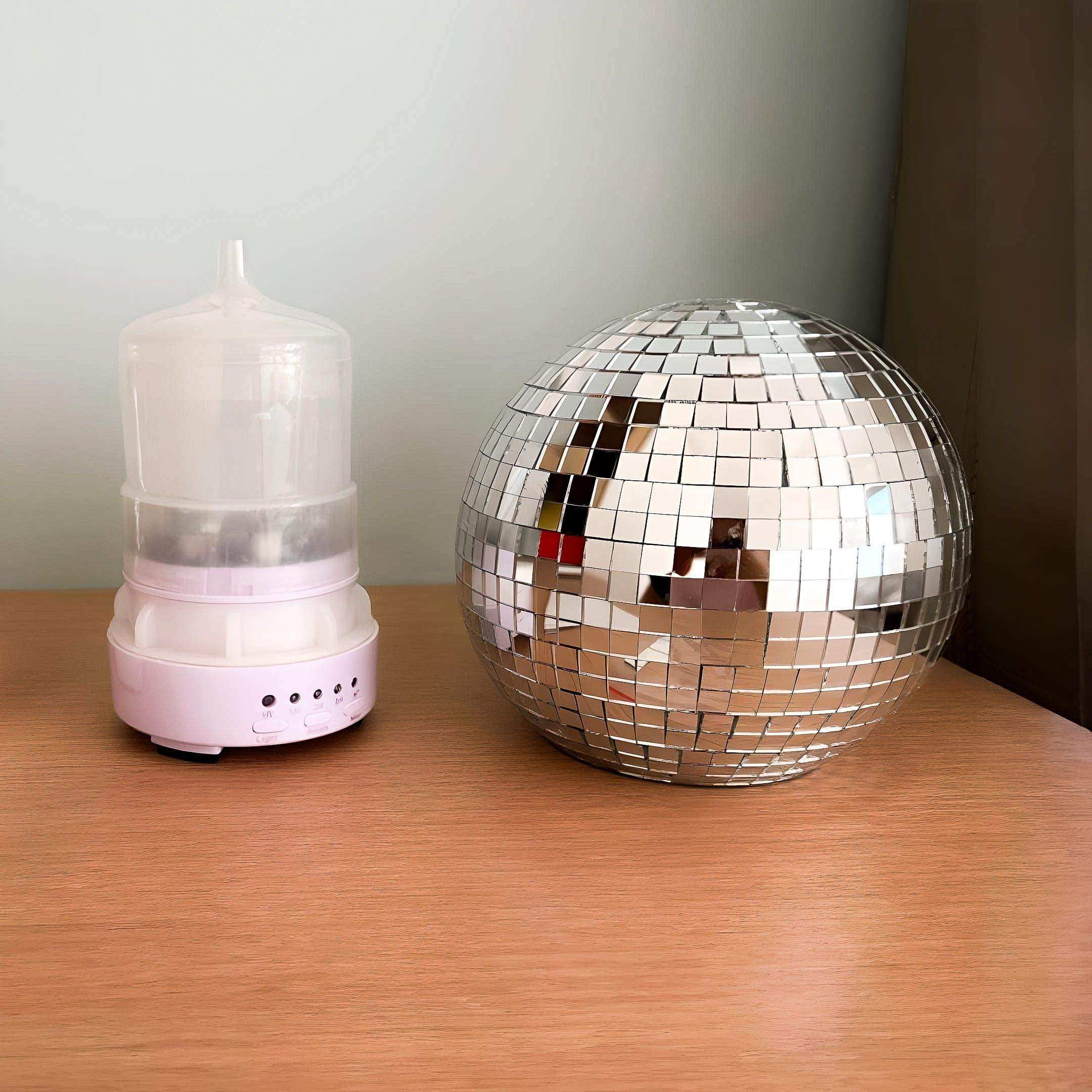 Shiny silver rotating disco ball diffuser with mirrored tile surface for fun rotating disco vibes at home