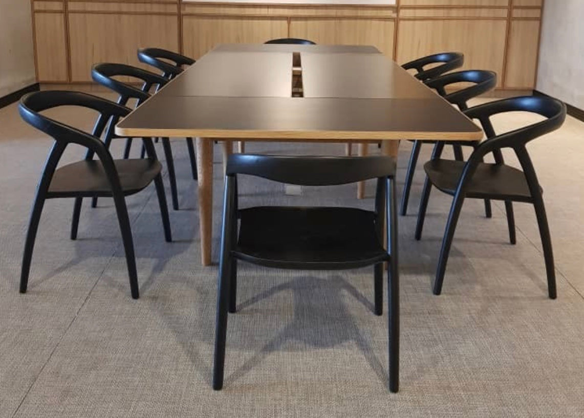 Modern black dining table with light wood accents and sleek minimalist design paired with the scandi arm chair