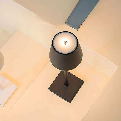 Black matte simplistic wireless led lamp with circular power button on illuminated top surface