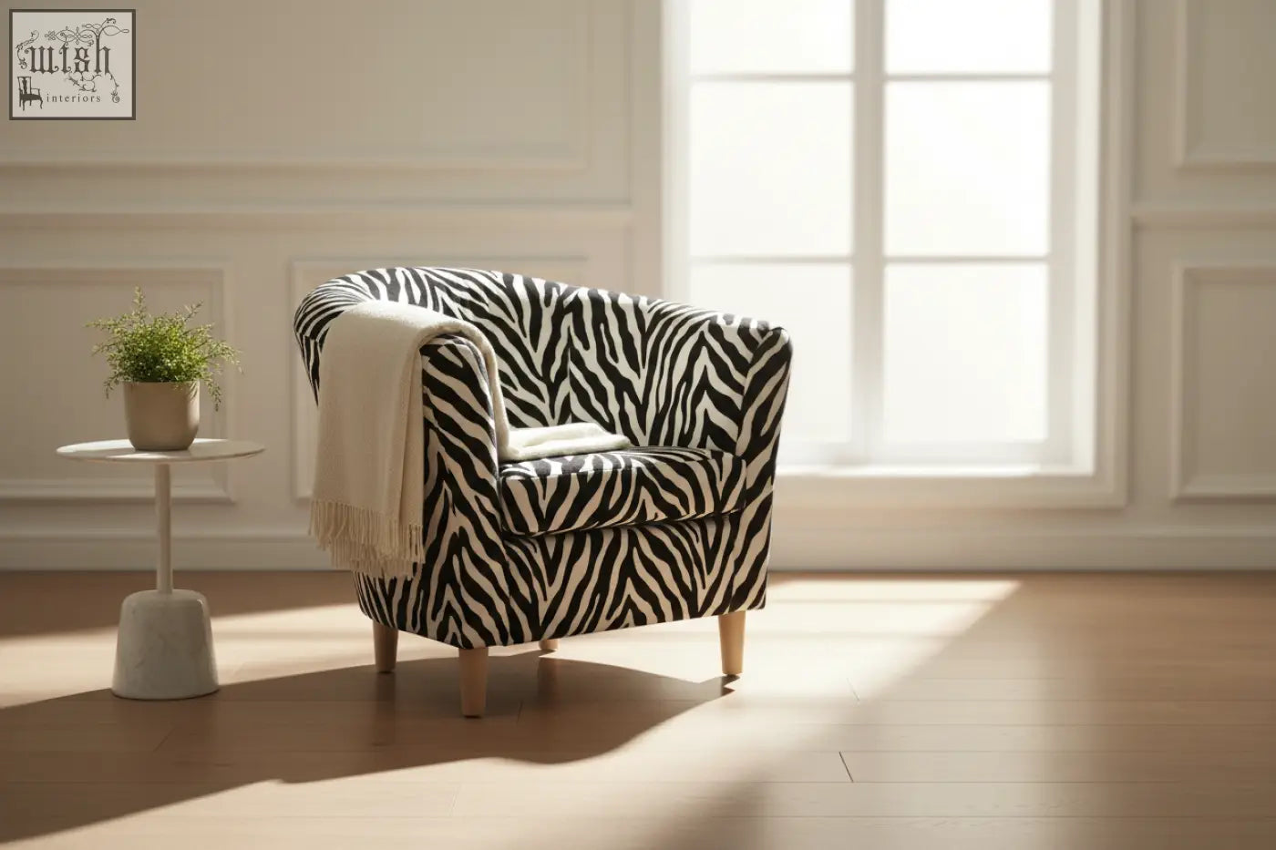 A cozy vibe tub chair with light wooden legs upholstered in bold black and white zebra print fabric