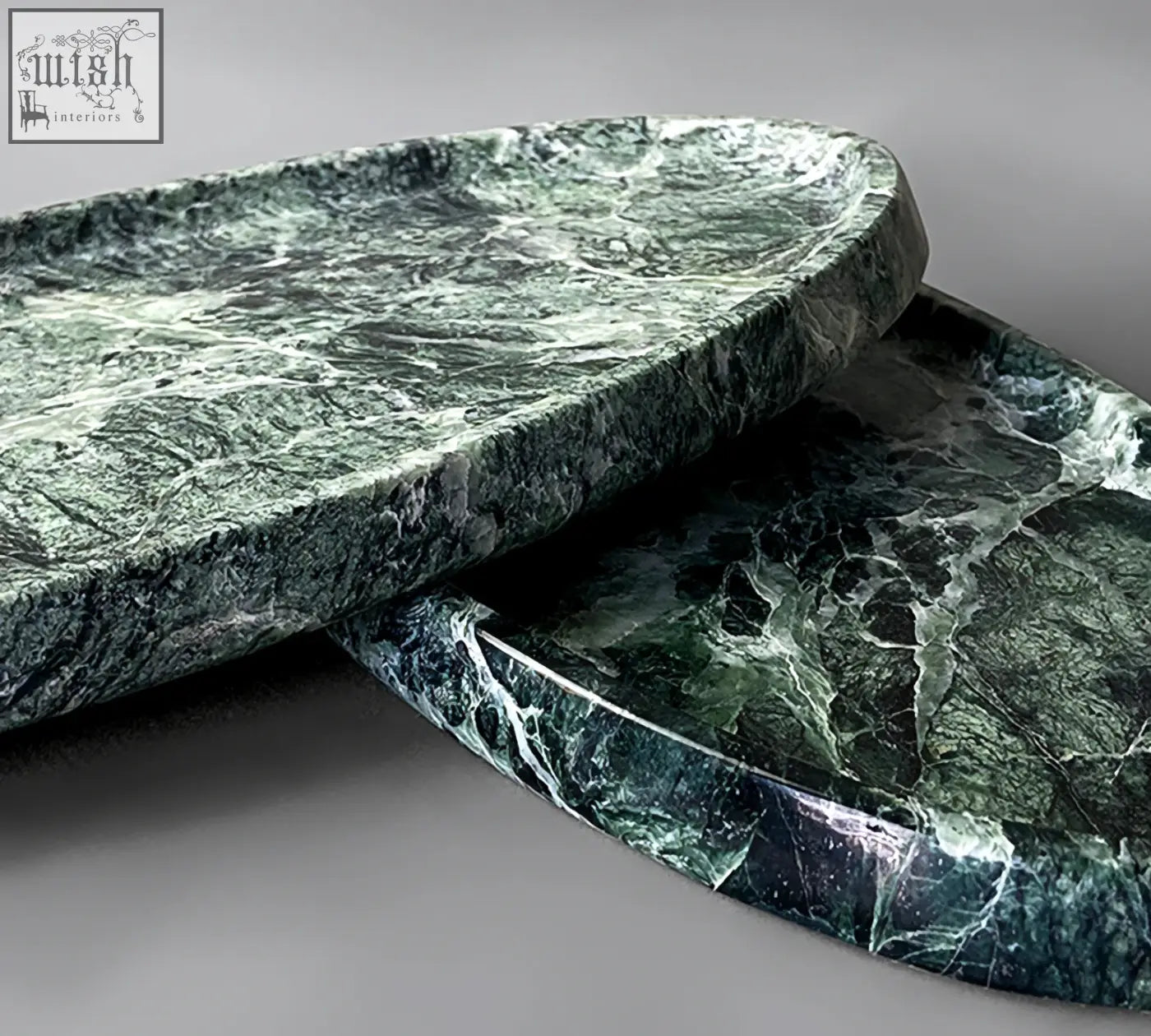Two oval-shaped thelonious marble trays with deep green and white veining make a stylish bathroom tray option