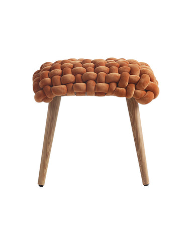 A cozy rust-colored thick knot dressing table stool with knitted texture and wooden legs