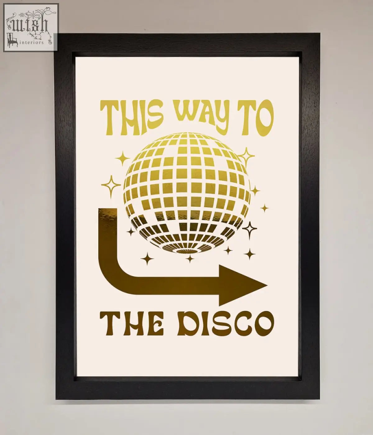 A framed off-white poster with gold disco foil print and text this way to the disco perfect for fun decor