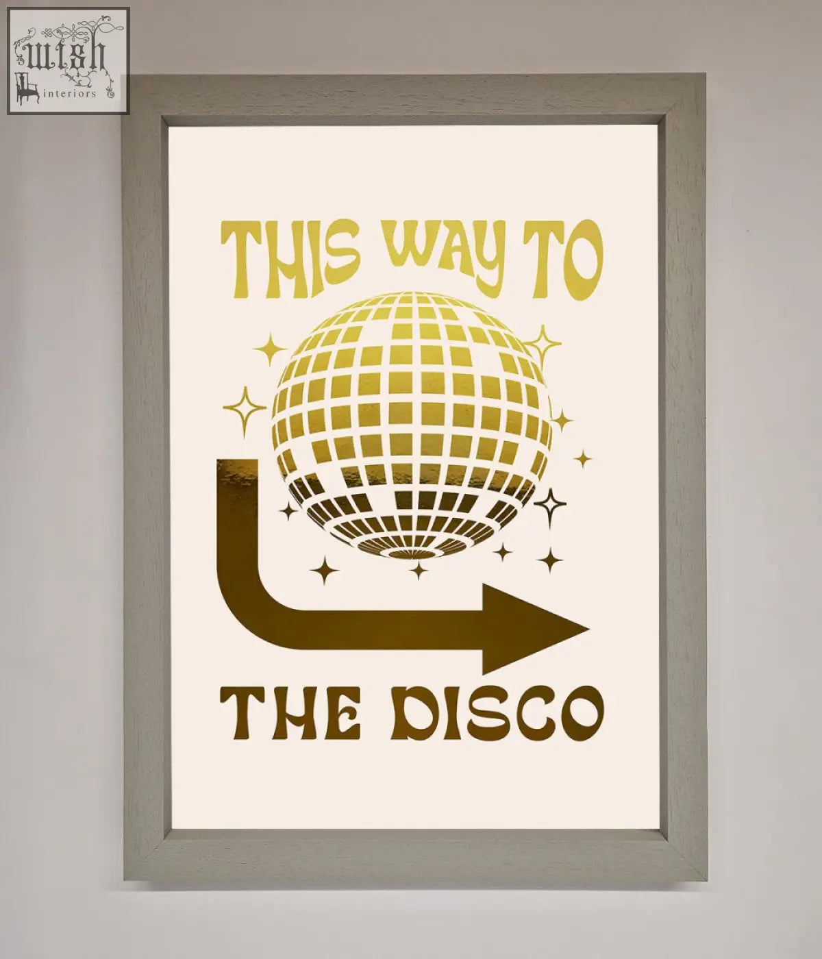 A framed poster with a gold disco foil print disco ball and arrow on an off-white background for party decor
