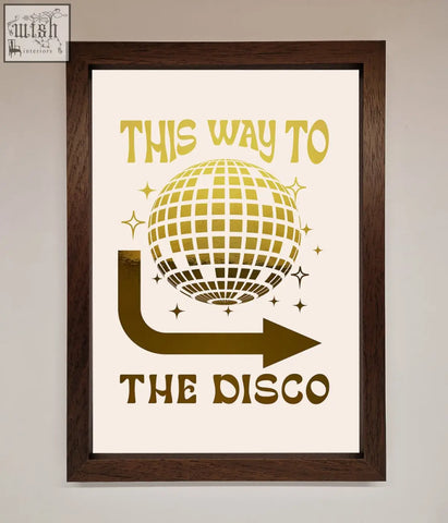 A framed poster disco foil print with gold disco ball and arrow design on an off-white background titled this way to the disco foil print