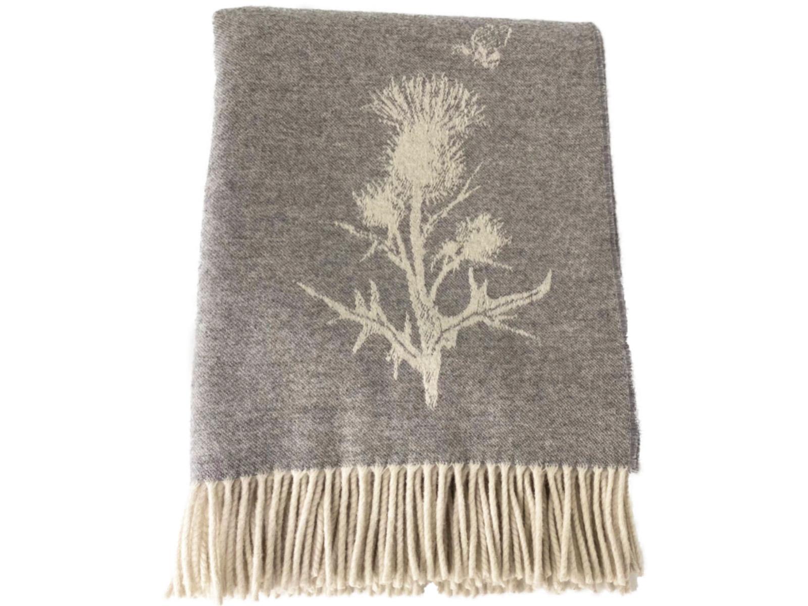 Gray merino lambswool throw blanket with cream thistle design and matching fringe perfect for cozying up