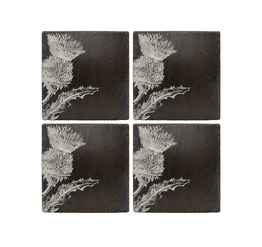 Set of four dark slate coasters with white etched thistle flower designs perfect for protecting surfaces