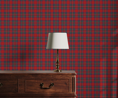 A classic brass thompson table lamp with a white tapered shade on a dark wood dresser by tartan wallpaper