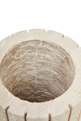 A beige tibor travertine ribbed vase featuring a rustic texture and notched rim perfect as a stone planter