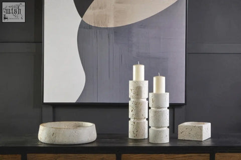 Stacked white textured candle holders on a tibor travertine square decorative bowl with cylindrical candles on top