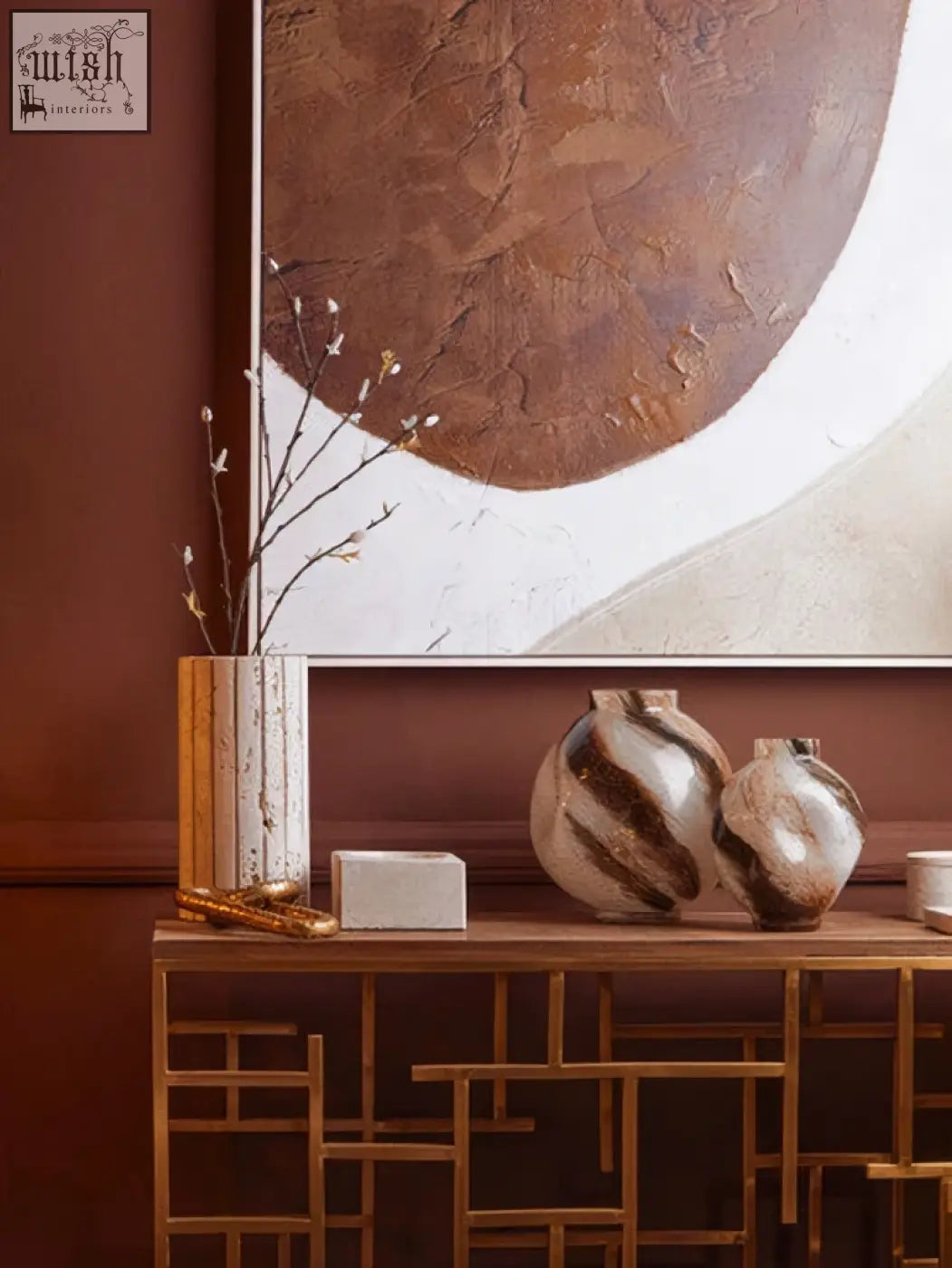 A tibor travertine square decorative bowl sits on an ornate wooden console with gold textured vase and marbled ceramics