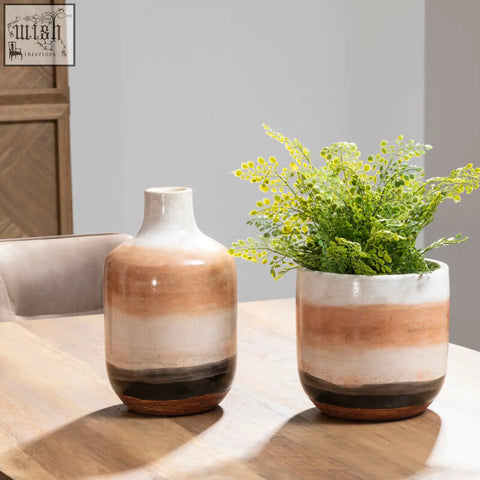 Terra cotta and white glazed natural earthenware planter with wide rim holding greenery for indoor decor