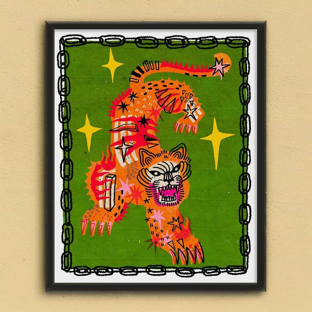 A vibrant orange tiger charm print with red and black accents surrounded by yellow stars in a sleek black frame