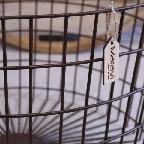 Dark brown metal industrial basket table with wood lid and marev tag hanging from the rim