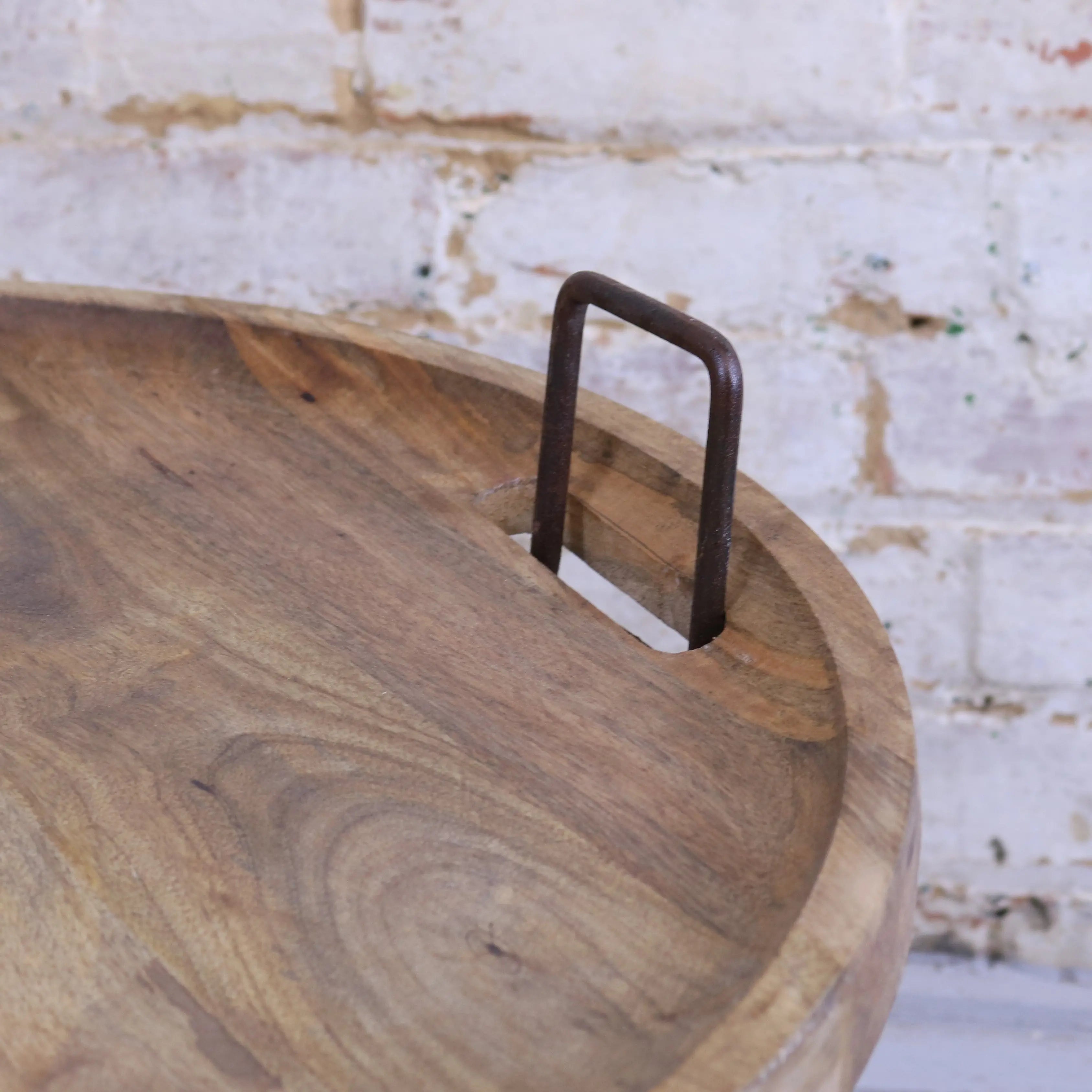 Rustic wooden serving tray with dark metal handle on tilpi industrial basket table with wood lid