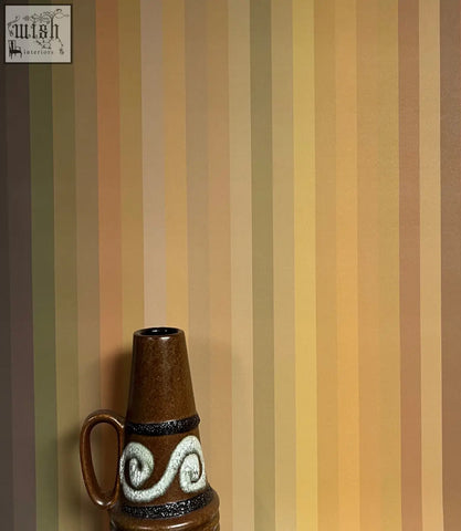 Brown ceramic vase with white swirls and black bands complementing tonal stripe wallpaper ochre colour ways