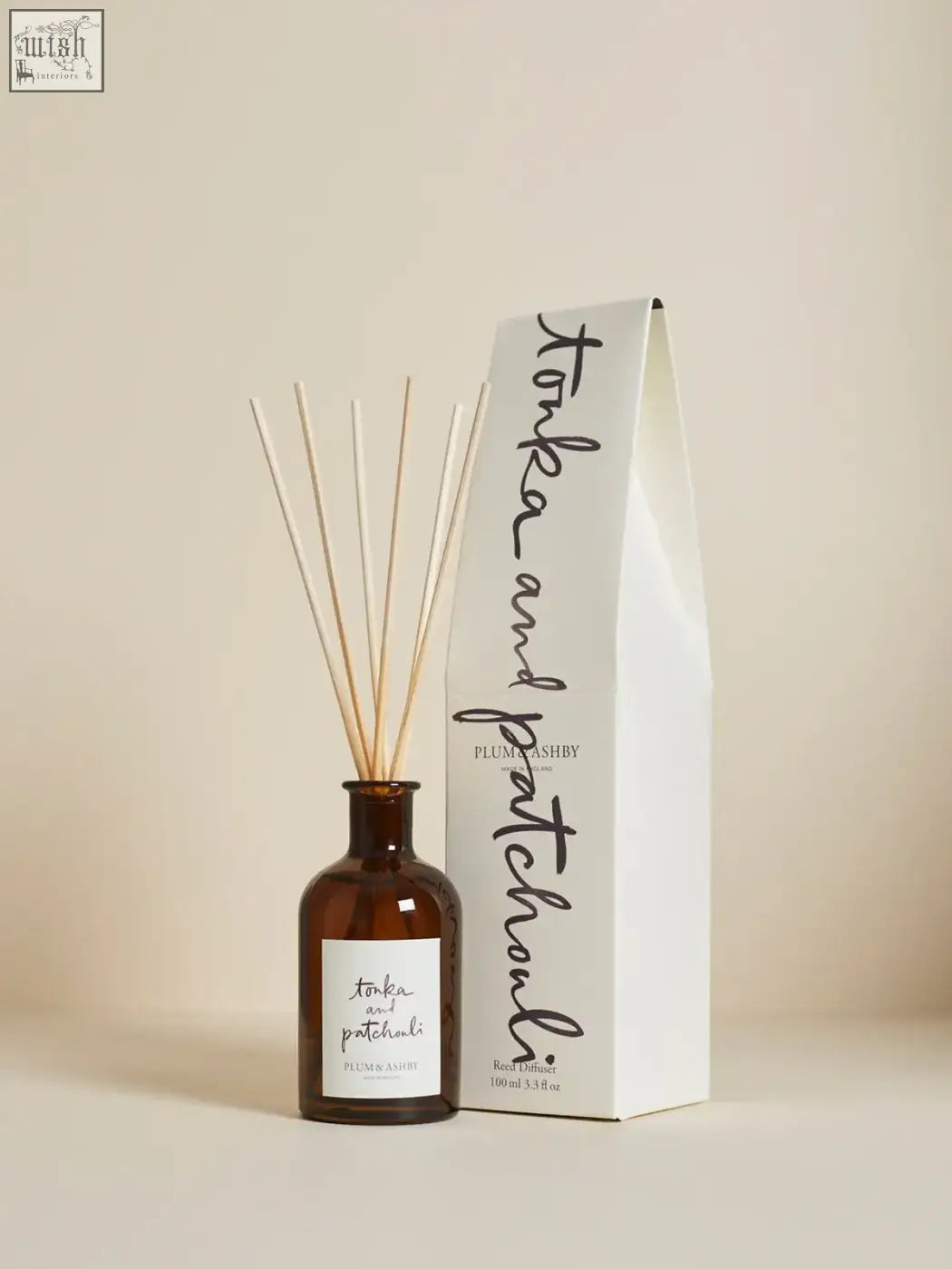 Brown glass reed diffuser with light wooden reeds and white label offering consistent fragrance throw of tonka bean and woody patchouli