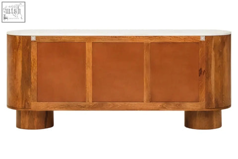 The back of a sleek torcino mango wood sideboard with carved design and three doors featuring tan leather panels