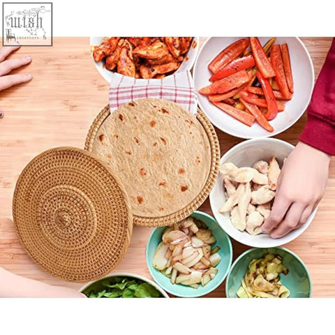 Woven rattan round tortilla warmer basket with matching lid holding flatbread and cotton tea towel on surface
