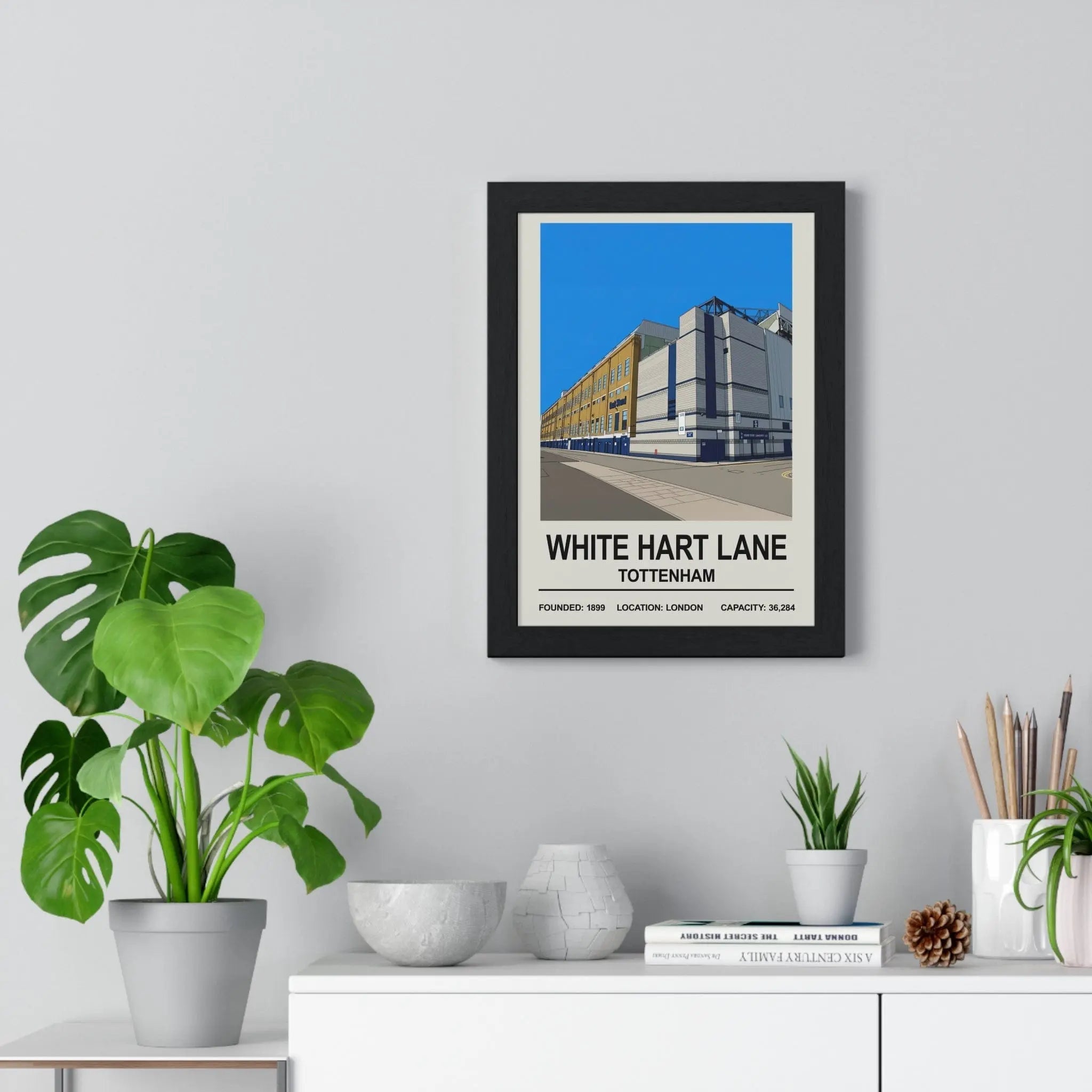 Black-framed white hart lane exterior print poster with bold typography and stylized illustration against blue sky