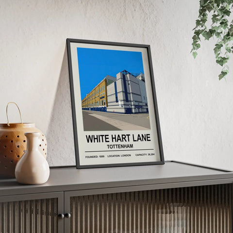 A framed print of white hart lane stadium with a bold black illustration and vibrant blue sky background