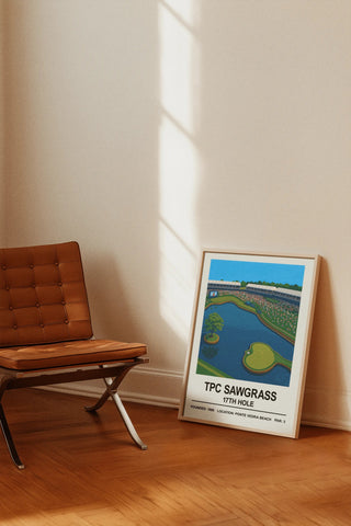 A framed tpc sawgrass 17th hole print featuring vibrant blue water and green fairways in a colorful illustration