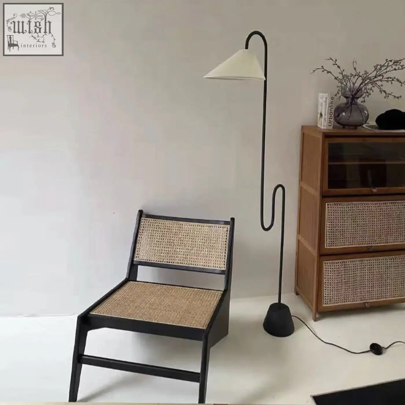 Black-framed tracyh lounge chair with woven natural rattan seat and backrest perfect for relaxing spaces