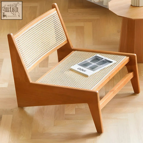 Minimalist tracyh lounge chair with light brown wooden frame and woven rattan seat and back perfect as a lounge chair