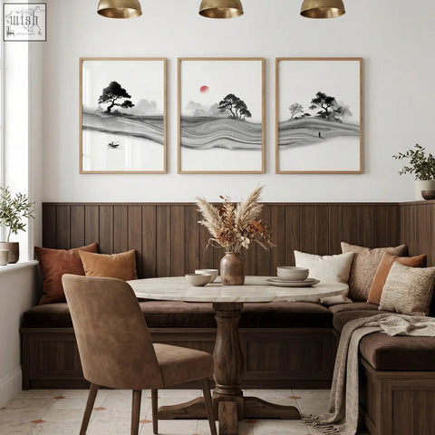 Round marble table with dark wood pedestal base next to traditional japanese wall art ink landscape with red moon set of 3