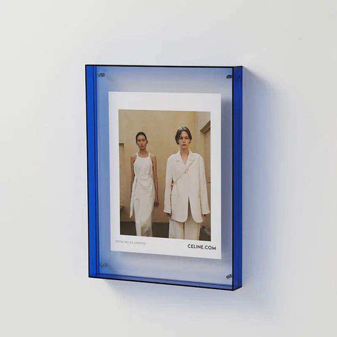 A translucent blue transparent acrylic picture frame holding a white celine photograph perfect for display