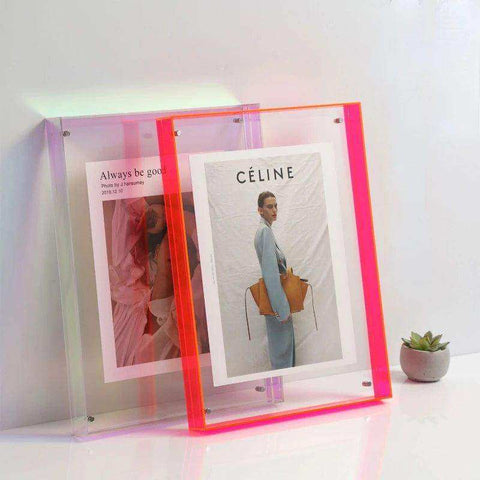 Vibrant neon pink and purple transparent acrylic picture frames holding fashion magazine pages in acrylic picture frame style