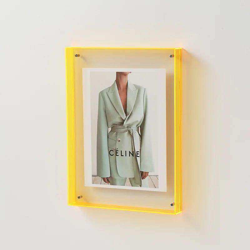 Vibrant yellow transparent acrylic picture frame holding a celine fashion magazine cover in an acrylic picture frame