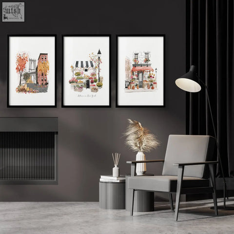Three framed watercolor travel art prints of autumn in new york city scenes hang on a dark gray wall