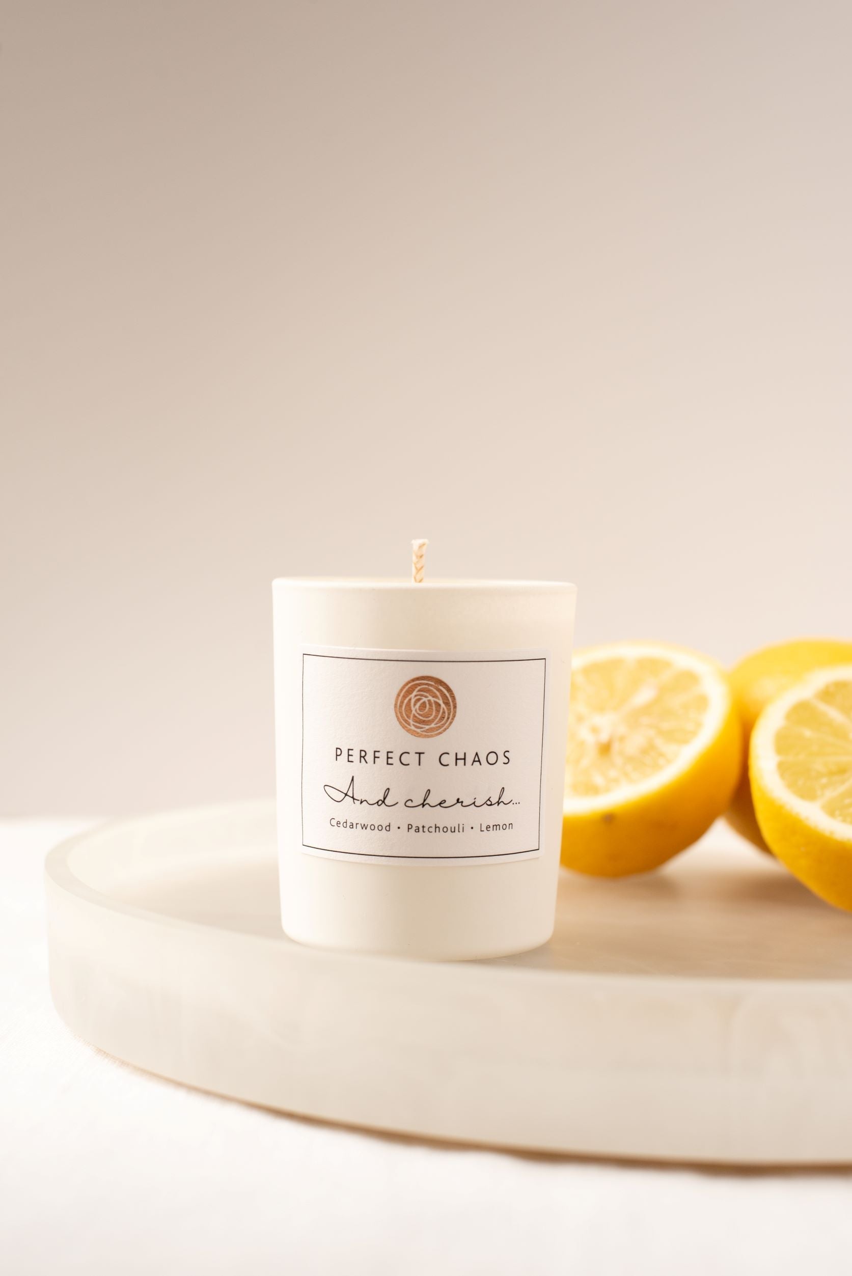 White cylindrical travel candle with minimalist perfect chaos and cherish label scented with cedarwood patchouli lemon essential oils