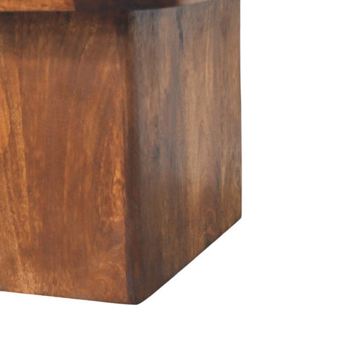 Rustic dark brown wooden cube with natural grain texture as base for travertine top coffee table