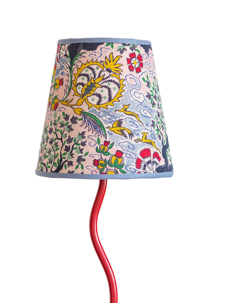 Tree of life lampshade with a vibrant red curved lamp base and a conical shade featuring colorful floral and bird motifs