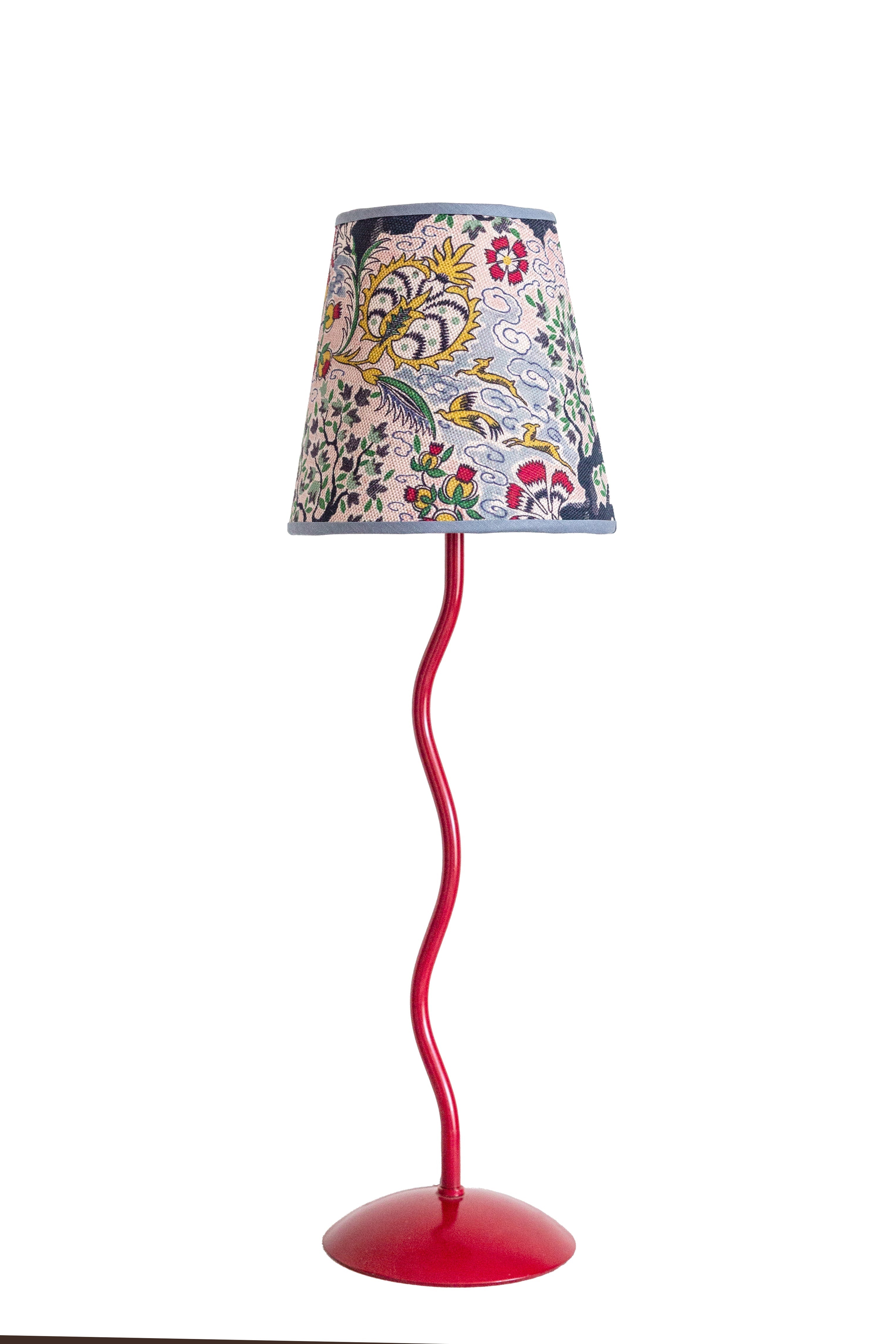 A vibrant red wavy metal floor lamp with a tree of life lampshade featuring embroidered floral and bird patterns