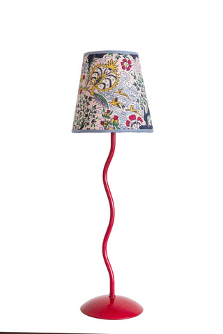 A vibrant red wavy metal floor lamp with a tree of life lampshade featuring embroidered floral and bird patterns