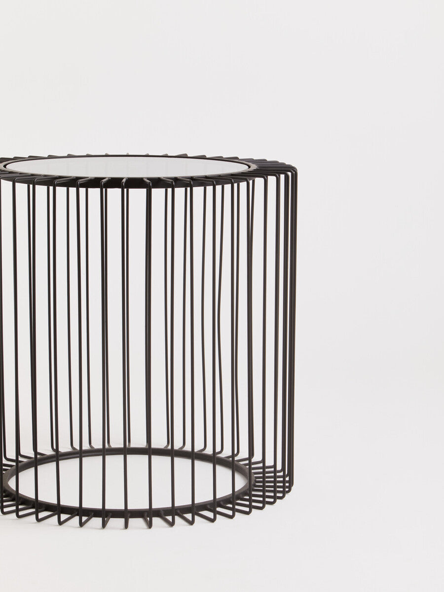 Trento black metal round side table with a black cylindrical wireframe base and clear glass top