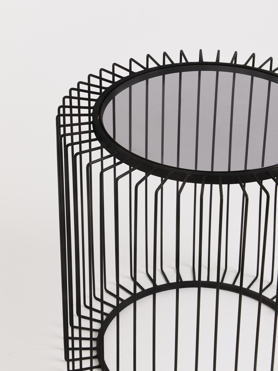 Black metal round side table with wireframe cylindrical base and mirrored glass top for modern living spaces